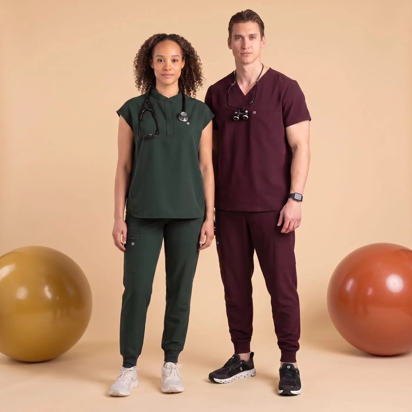 Two people wearing scrub sets in forest green and burgundy