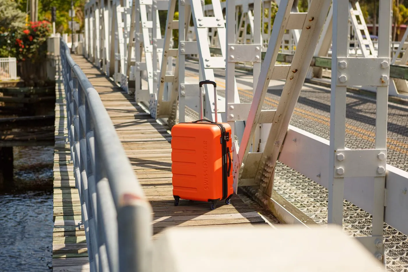 Orange SwissGear suitcase on a white bridge