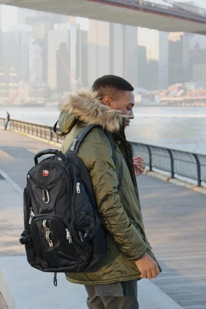 Man in a parka with a SwissGear backpack by the water