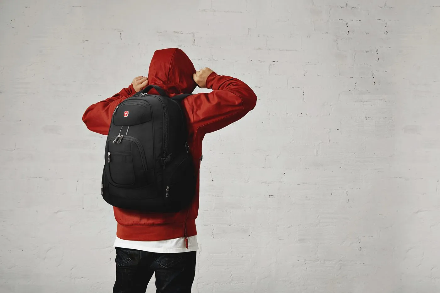 Person in a red hoodie wearing a SwissGear backpack