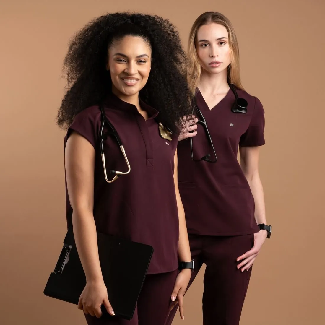 Two models in maroon and mauve scrub sets