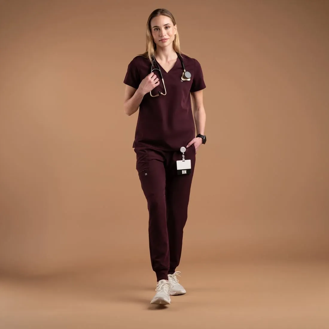 Model walking in a plum scrub set