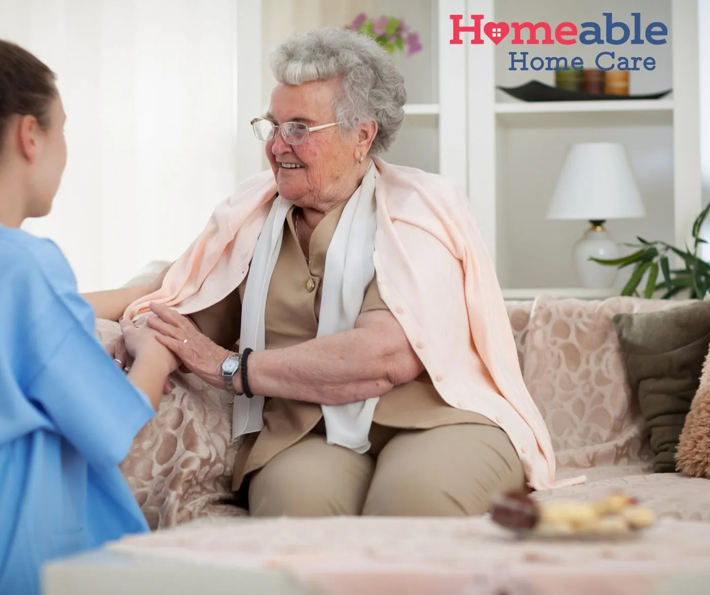 Homeable caregiver sitting with an older woman at home